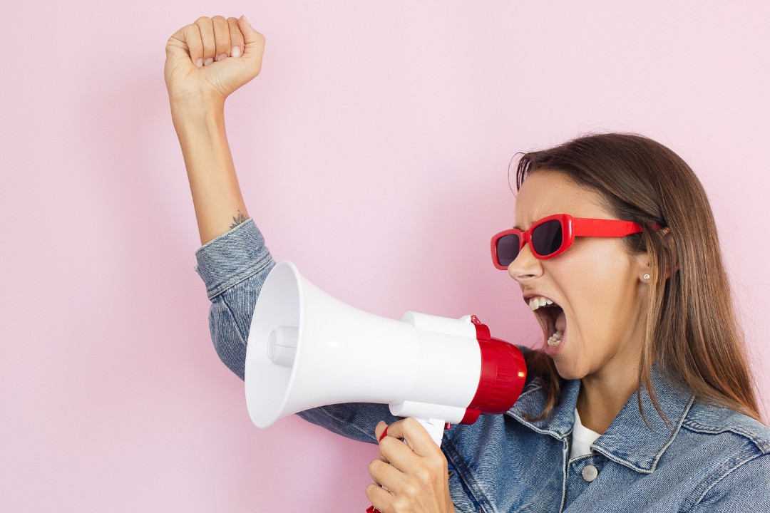 women shout into megaphone