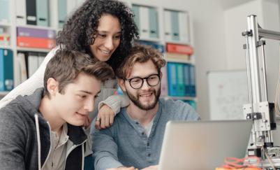 three young people looking at a laptop screen