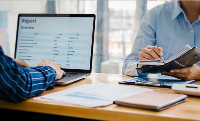 Person typing on laptop Keyboard while other writes in a notebook